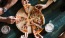 a group of people eating pizza